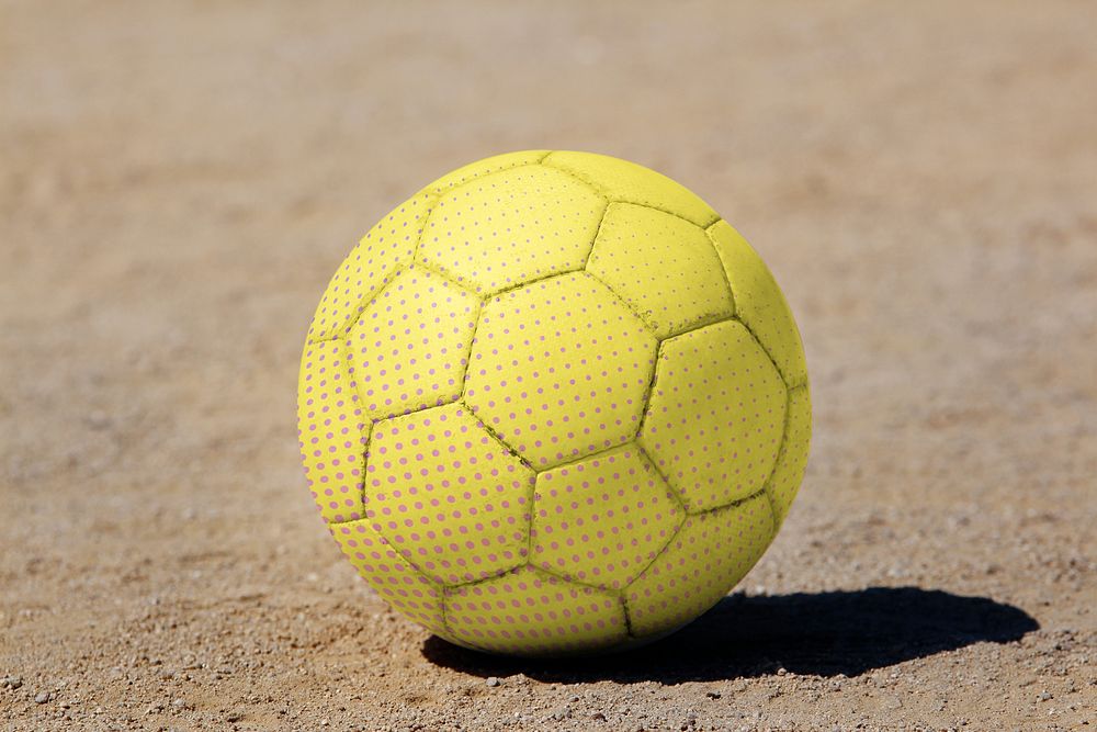 Yellow soccer ball on dirt