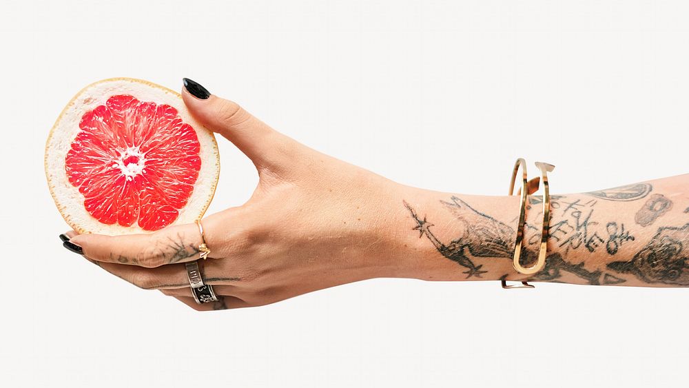 Tattooed woman holding a grape fruit isolated image