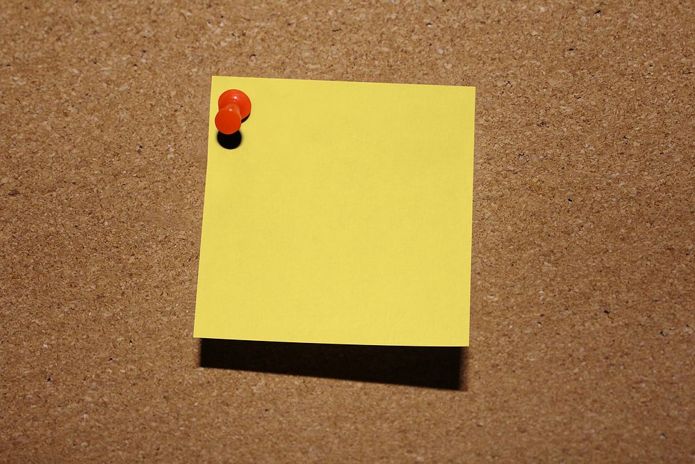 Blank yellow note on cork board