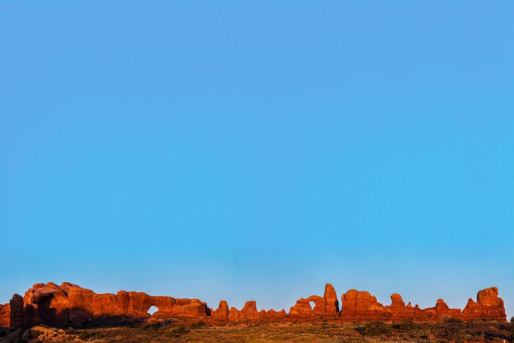 Sandstone arches border sky background