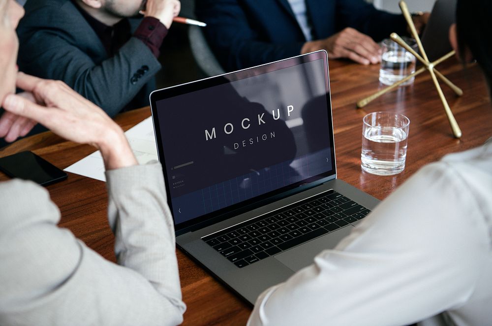 Business people using a laptop screen mockup in a meeting