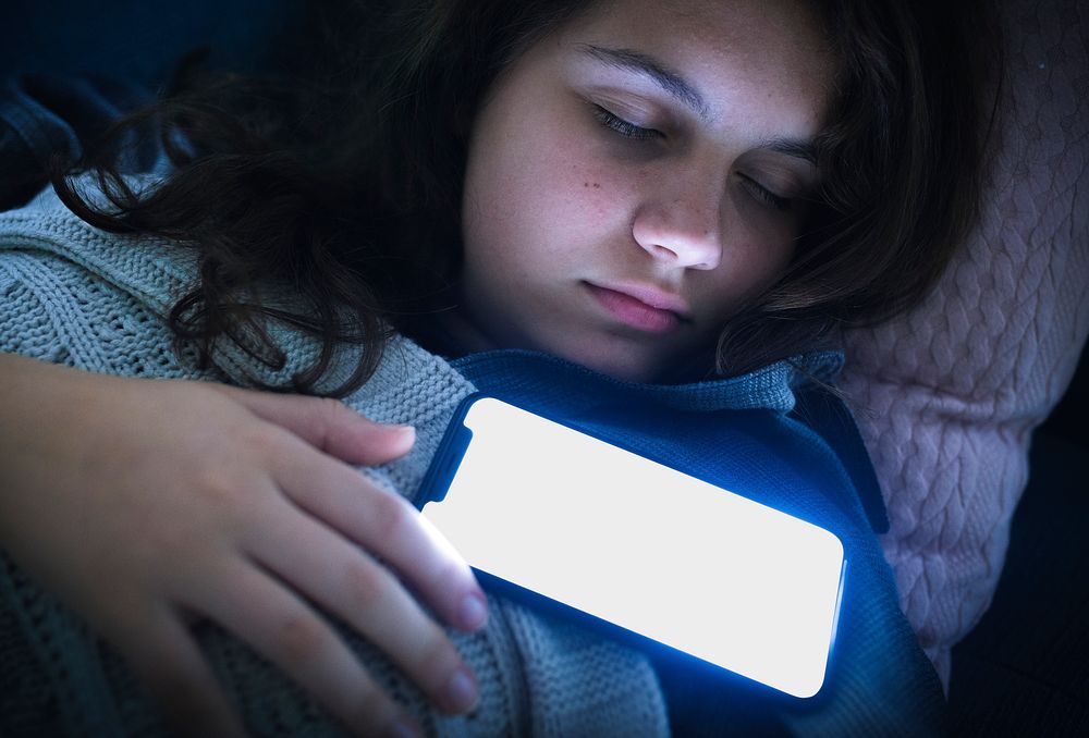 Girl fast asleep with her phone on her chest