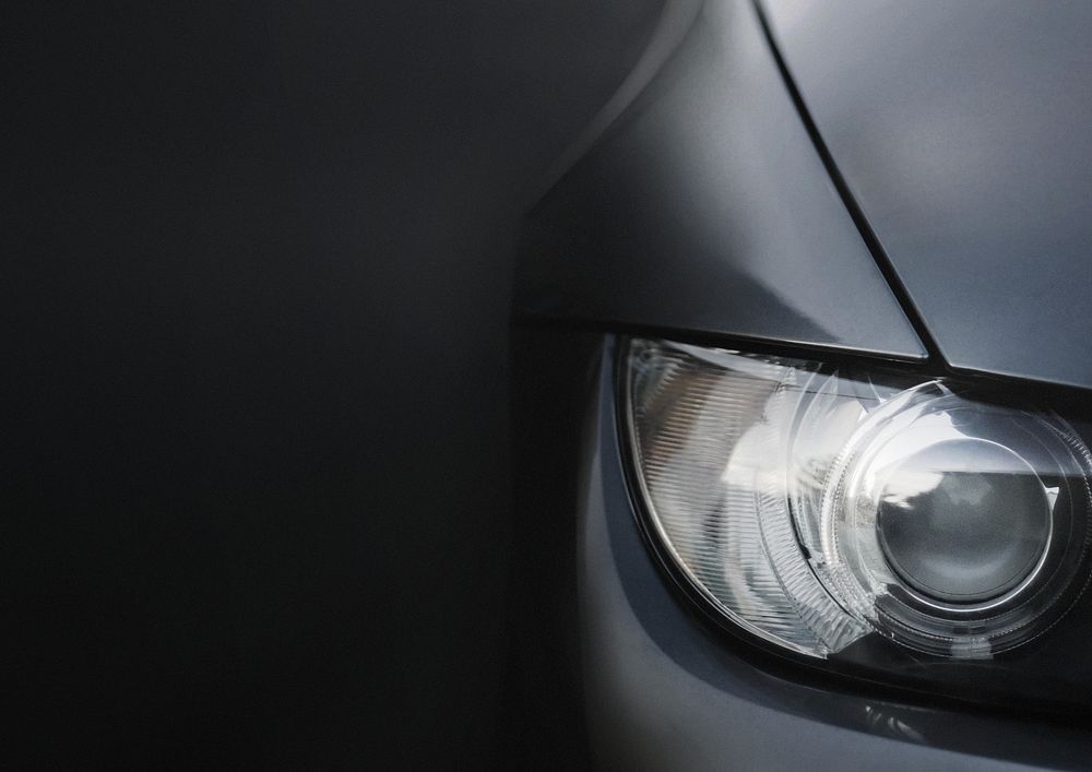 Silver car's headlight closeup background