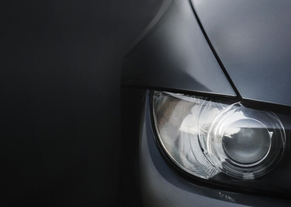 Silver car's headlight closeup background