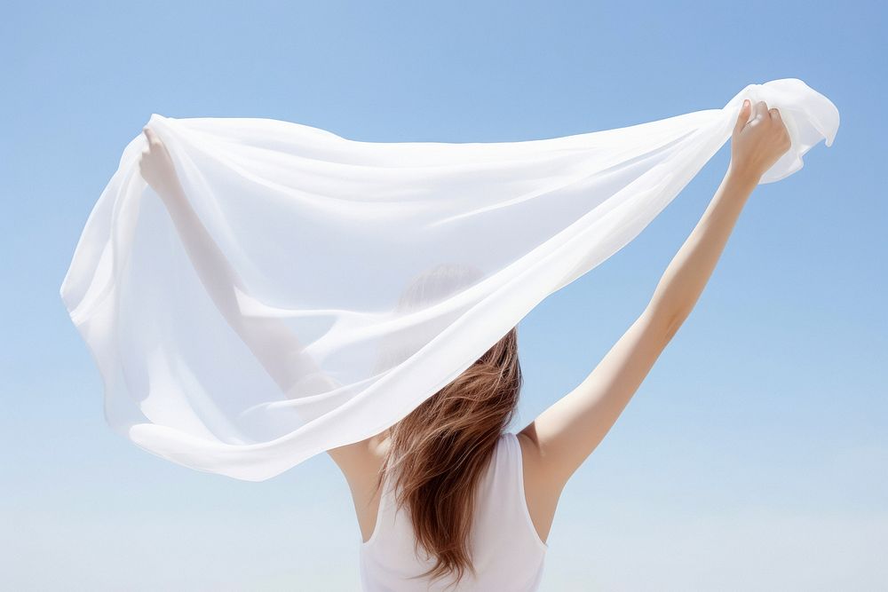 Woman holding white scarf, rear view. 