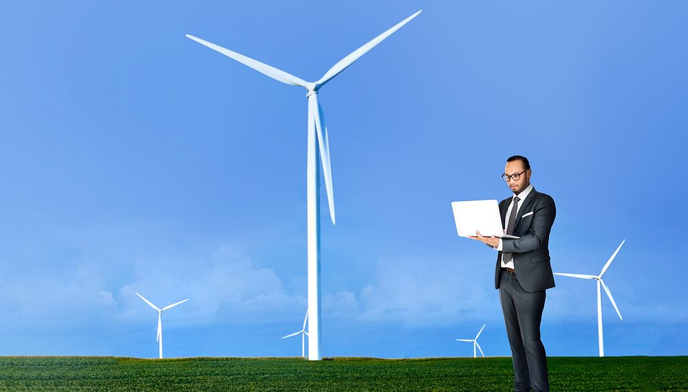 Wind turbine background, businessman using laptop image