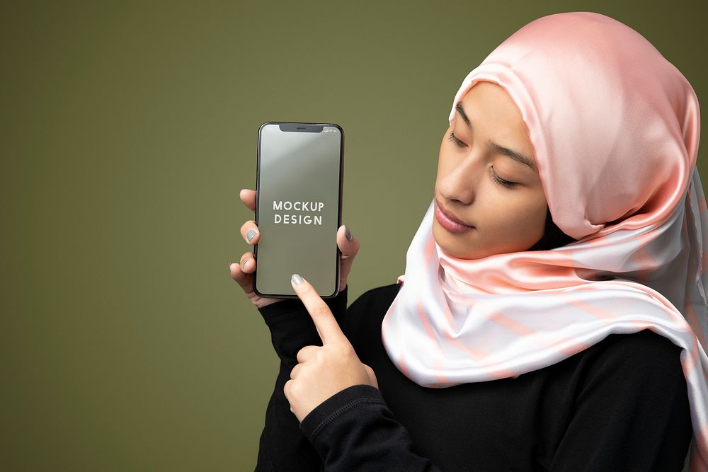 Muslim woman showing a mobile screen mockup in a green background