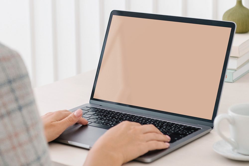 Person working on laptop, blank screen 