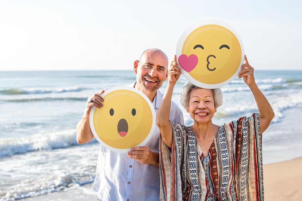Mature couple holding emoticon sign