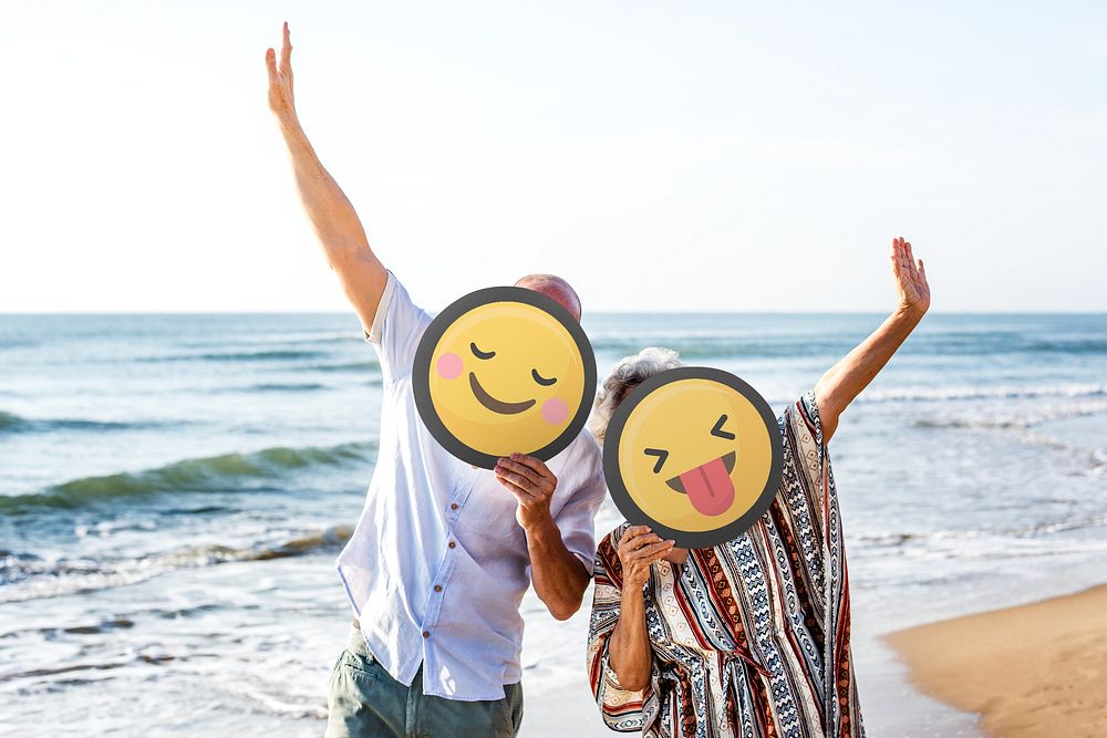 Mature couple holding emoticon sign