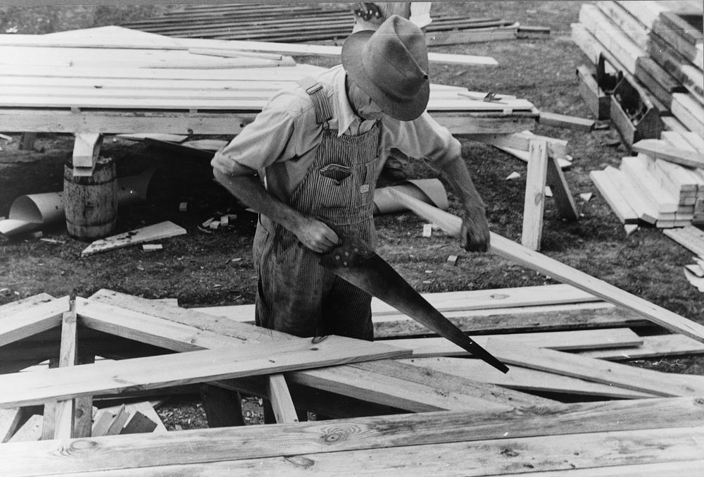 Carpenter working on gable of prefabricated house, Roanoke Farms, North Carolina. Sourced from the Library of Congress.