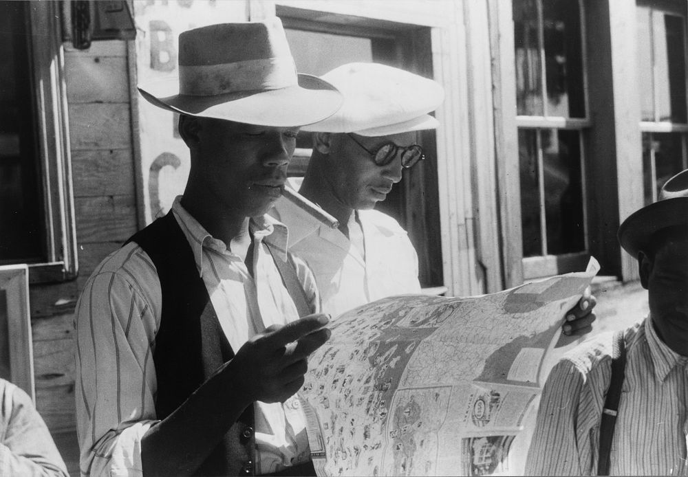 Florida migrants studying road map before leaving Elizabeth City, North Carolina for the state of Delaware. Sourced from the…