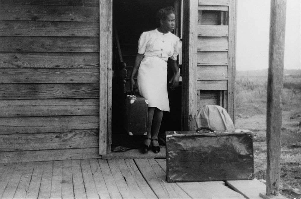 Florida migrant bringing her luggage out in preparation for a trip from Belcross, North Carolina to another job at Onley…