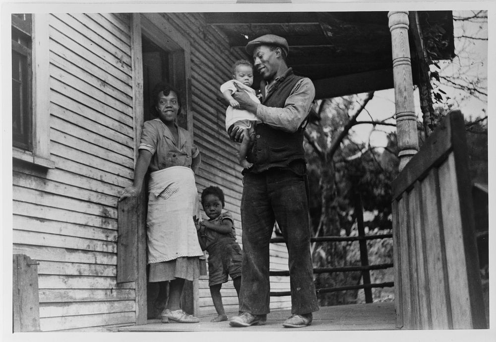 Coal miner, his wife and two of their children (note child's legs). Bertha Hill, West Virginia. Sourced from the Library of…