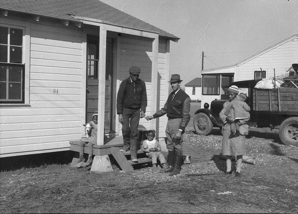 Hugh Edwards,  assistant camp manager, presents key to new home to Hunter family. Southeast Missouri. Sourced from the…