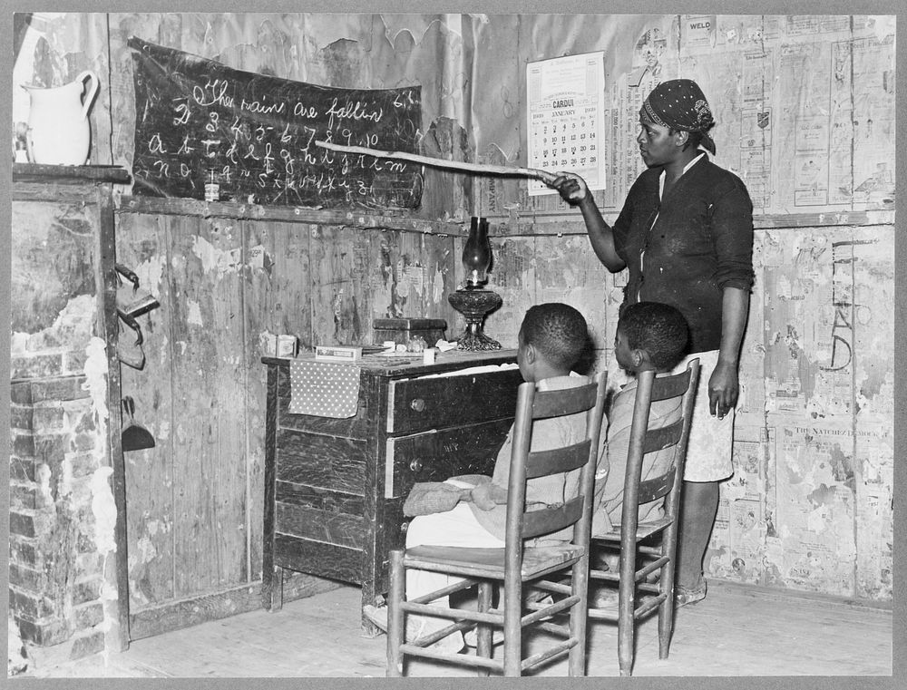 Mother teaching children numbers and alphabet in home of sharecropper. Transylvania, Louisiana by Russell Lee