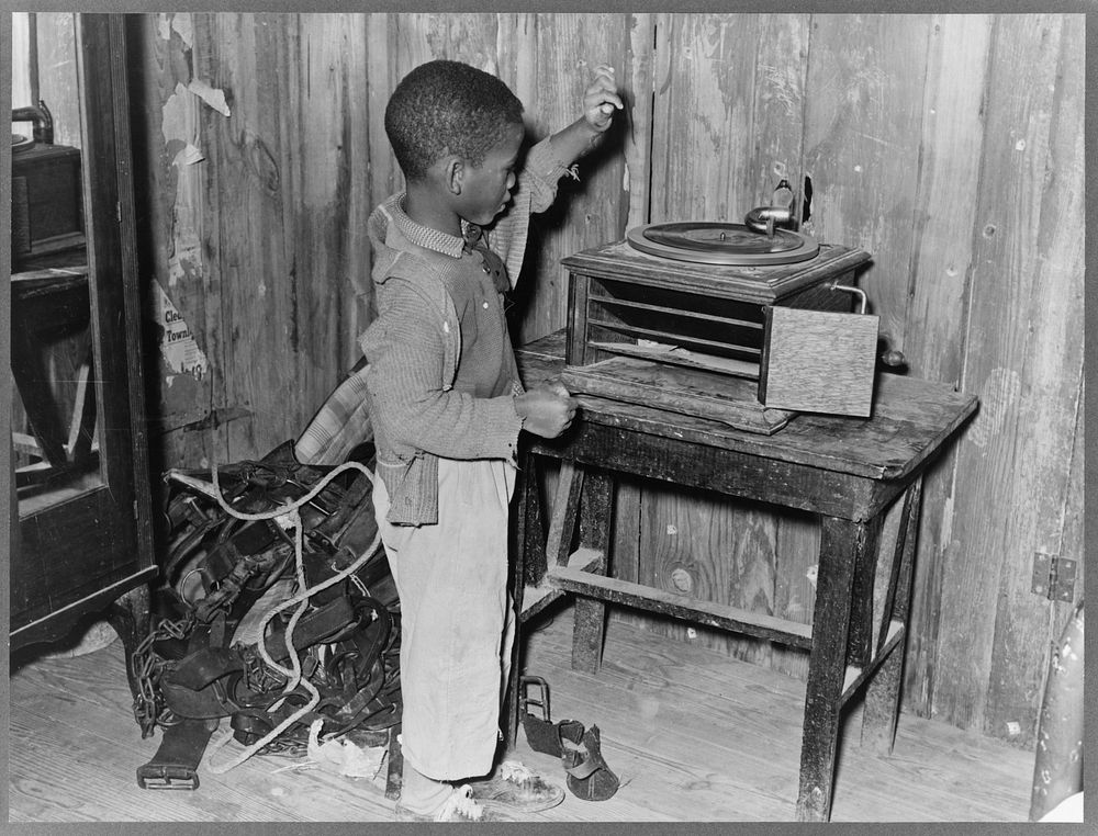 Child playing phonograph in cabin home. Transylvania Project, Louisiana by Russell Lee