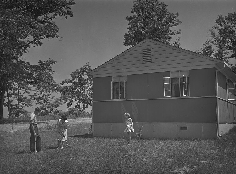 Sheffield, Alabama (Tennessee Valley Authority (TVA)). Kenneth C. Hall and family play croquet outside their home built by…