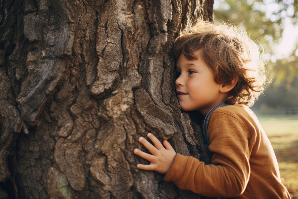 Little boy hugging a tree. 