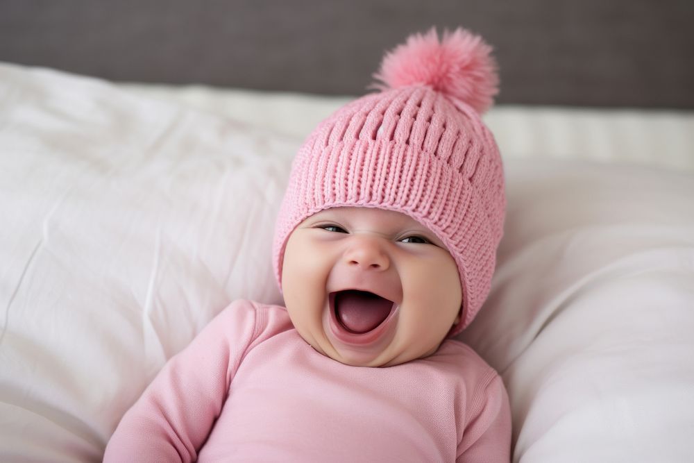 Baby laughing pink bed. 