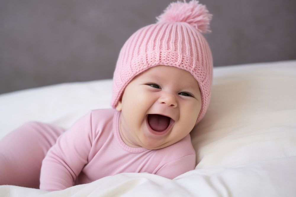 Baby laughing pink bed. 