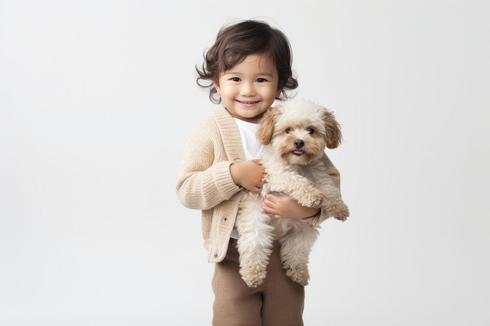 Portrait toddler holding mammal. 