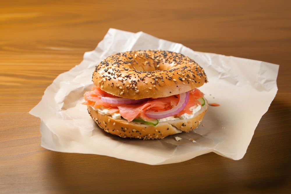 Close-up of Lox Bagel with onions on paper sheet.  