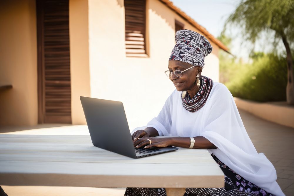 Senior african woman laptop computer sitting. AI generated Image by rawpixel.