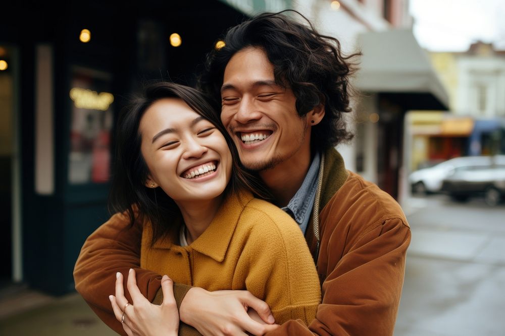 Asian couple laughing smiling hugging. 