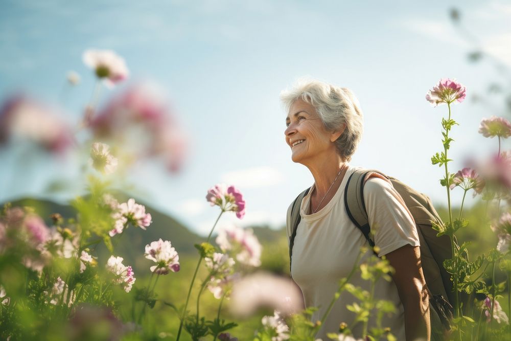 Senior woman hiking through flower field outdoors nature adult. AI generated Image by rawpixel.