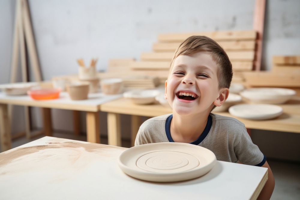 Happy kid painting pottery table child. 