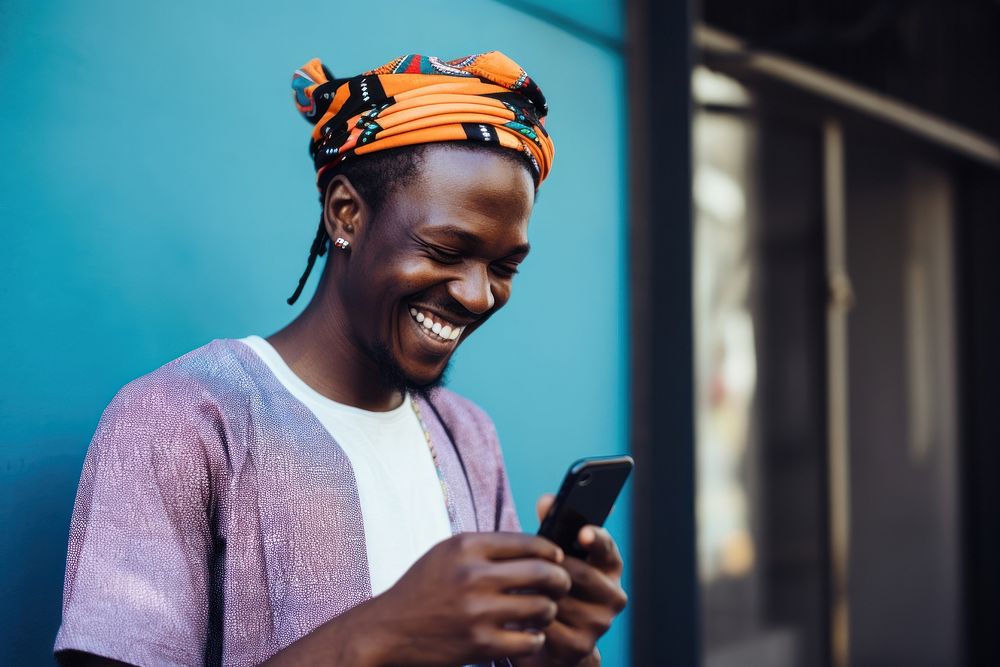 African man smiling looking mobile phone. AI generated Image by rawpixel.
