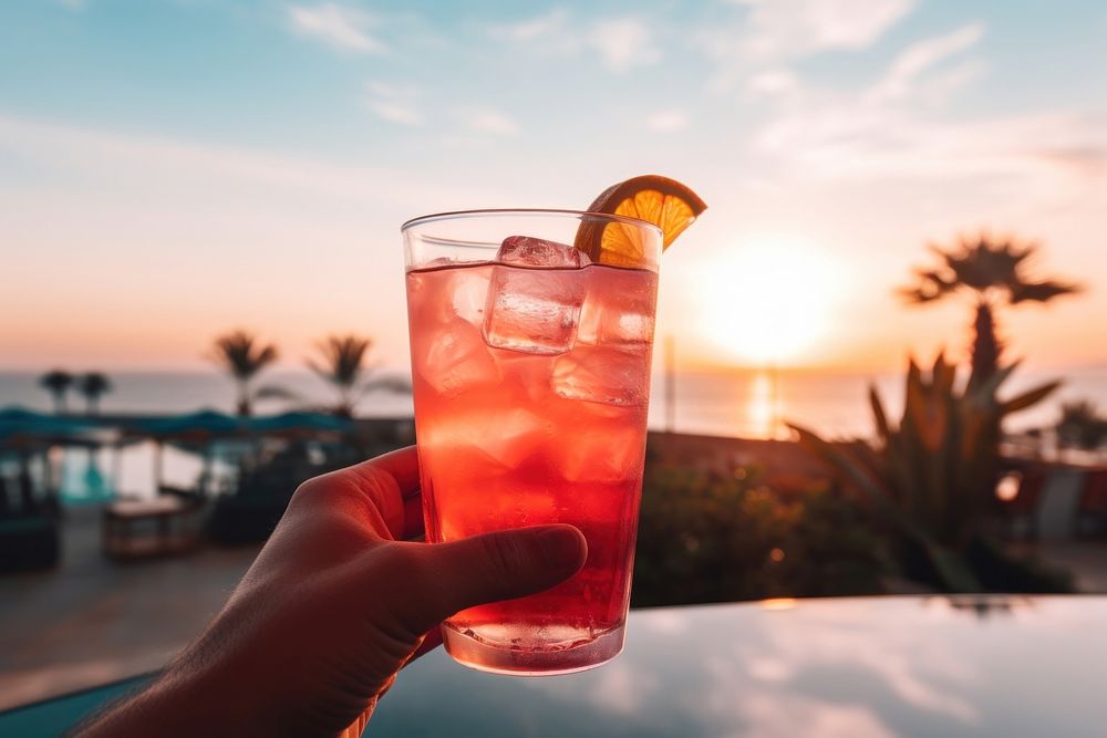 Malibu sunset cocktail outdoors holding mojito. AI generated Image by rawpixel.
