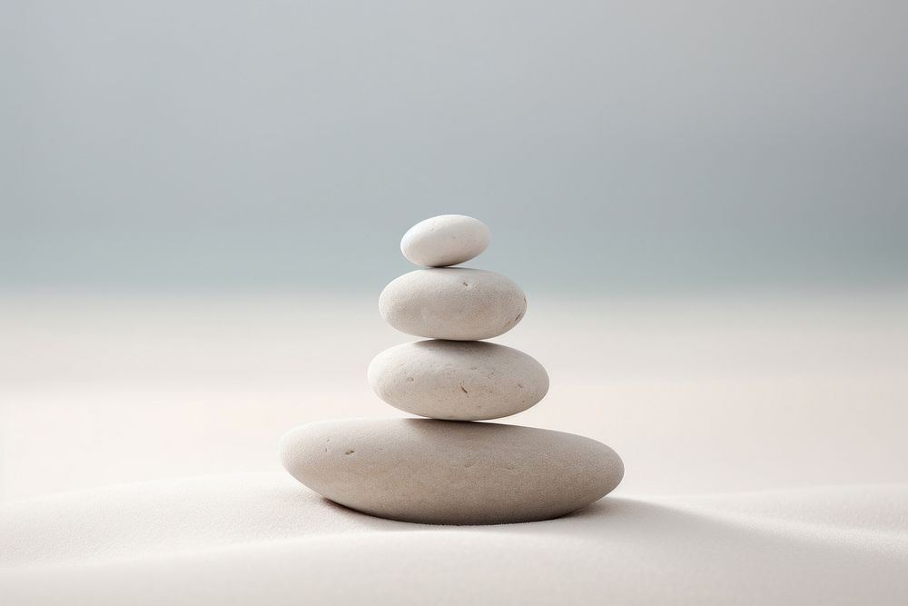 Rocks sitting on top of a white surface on sand pebble pill medication.