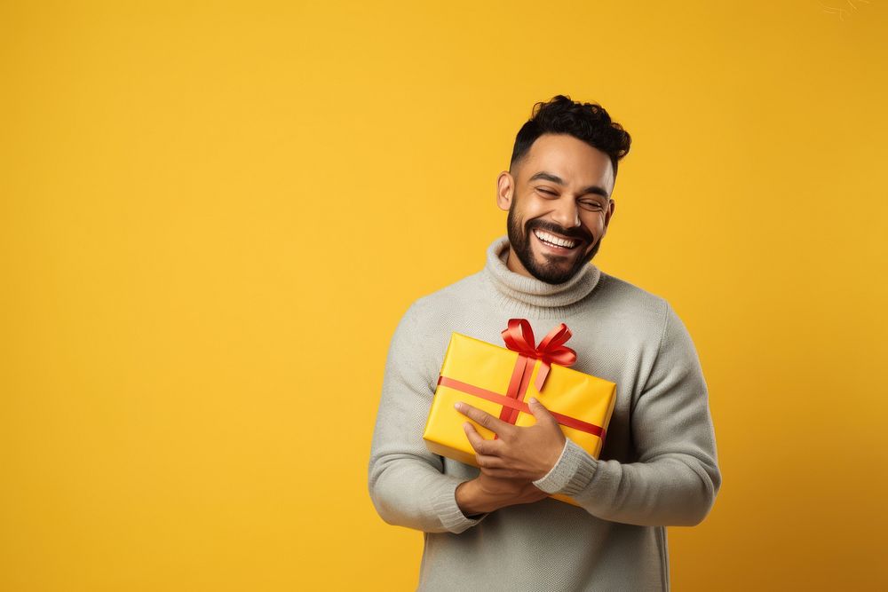 Latin man smiling yellow gift. 