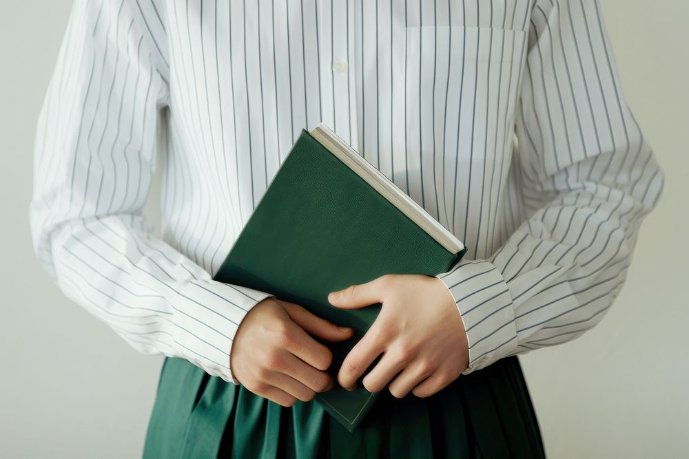 Hand holding a dark green book pattern person shirt. 