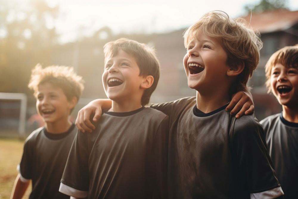 Young football players cheering cheerful laughing child. 