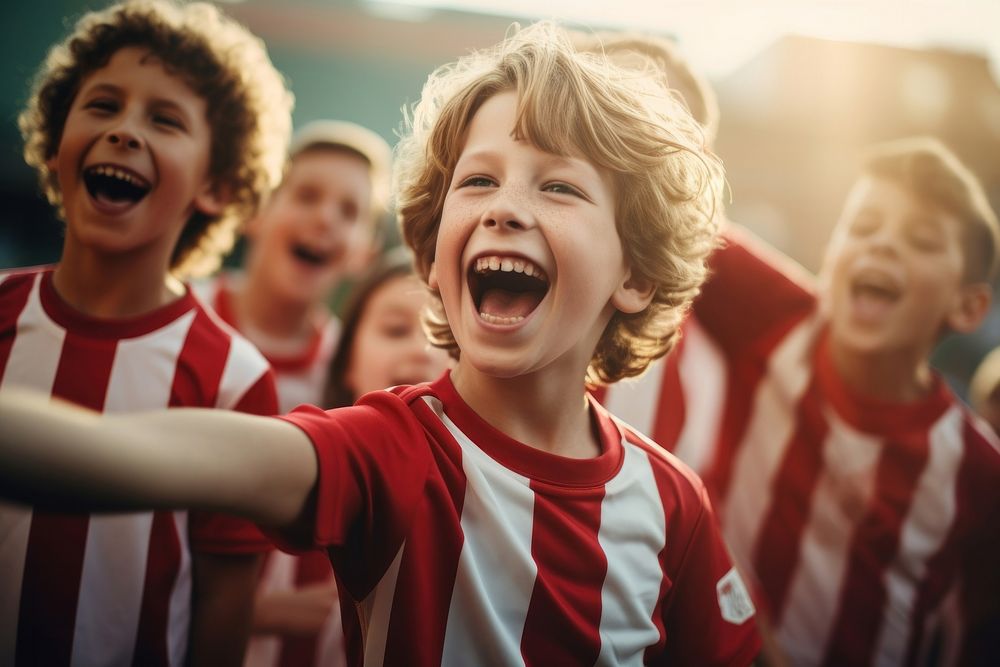 Young football players cheering cheerful laughing child. 