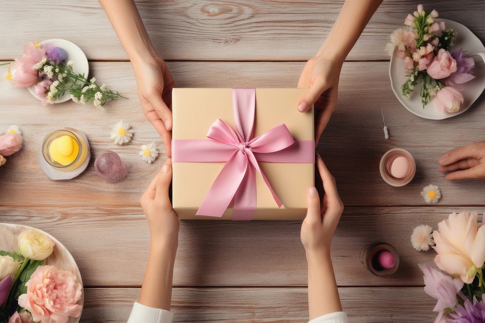 Hands exchanging gift box birthday table celebration. AI generated Image by rawpixel.