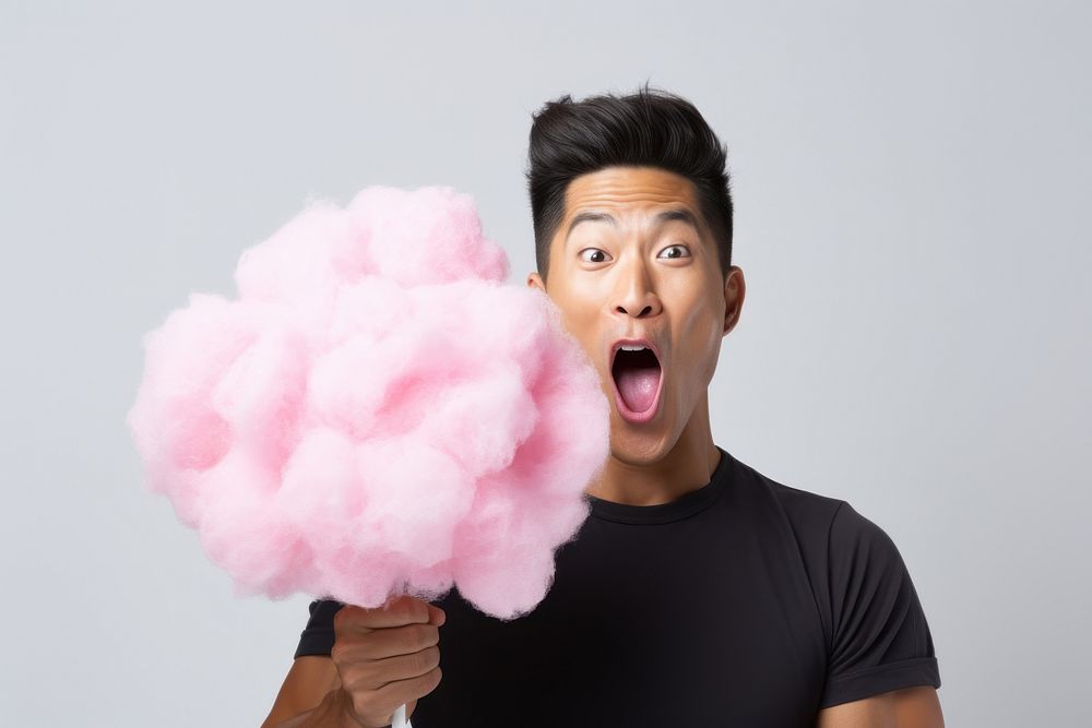 Asian man eating cottoncandy happiness surprised vitality. AI generated Image by rawpixel.