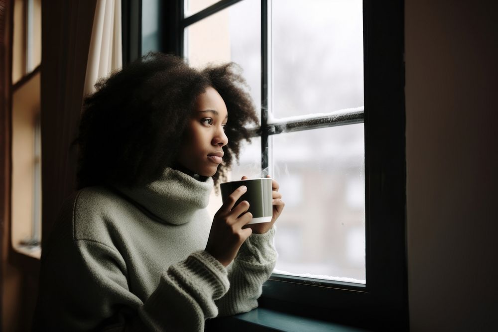 Photo of Thoughtful black woman with coffee cup looking through window in winter season. AI generated Image by rawpixel. 