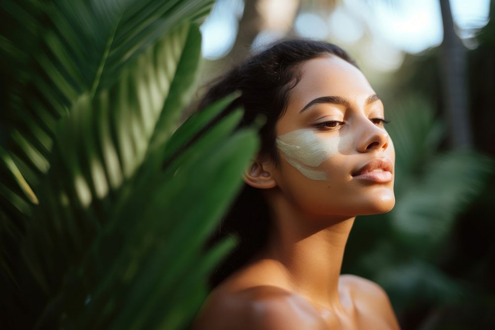 close up side profile photo of a hispanic woman face with subtle pastel green face mask cream.  