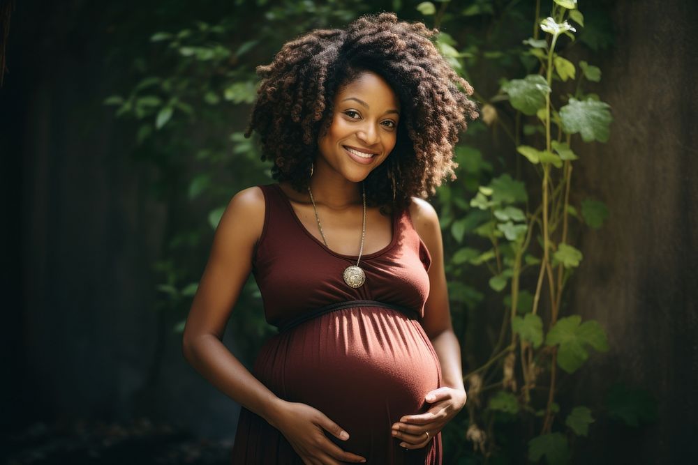 Pregnant black woman smiling holding smile. 