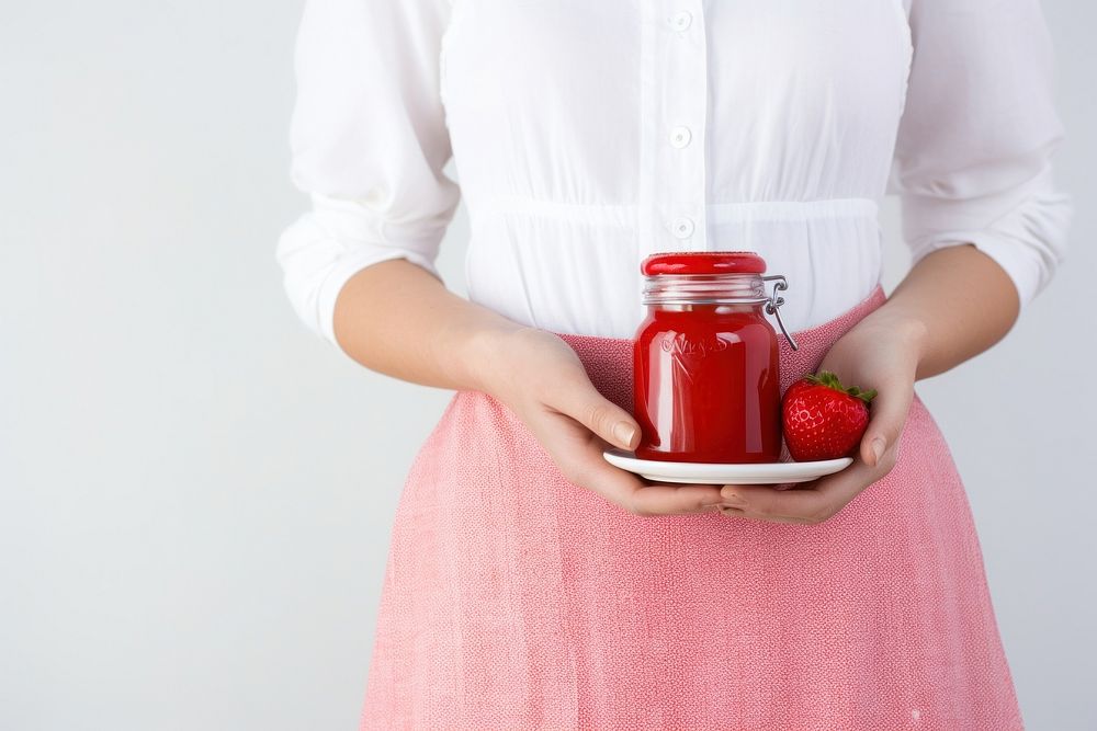 Strawberry jam holding food jar. 