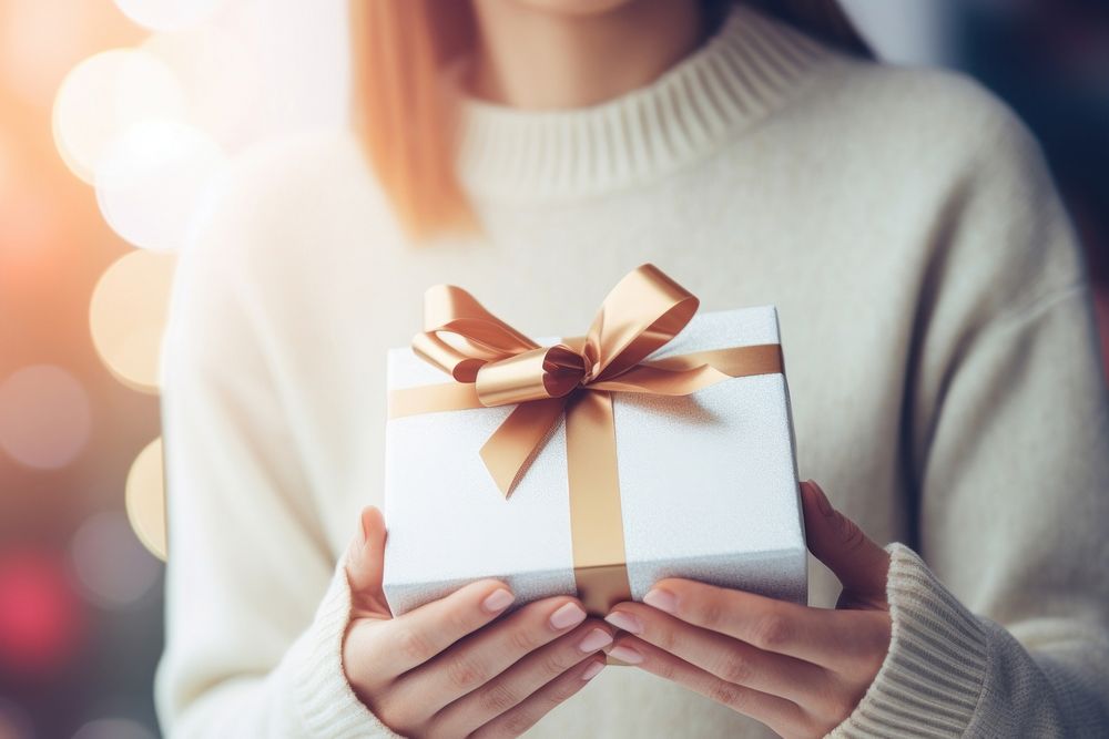 White gift box sweater holding adult. AI generated Image by rawpixel.