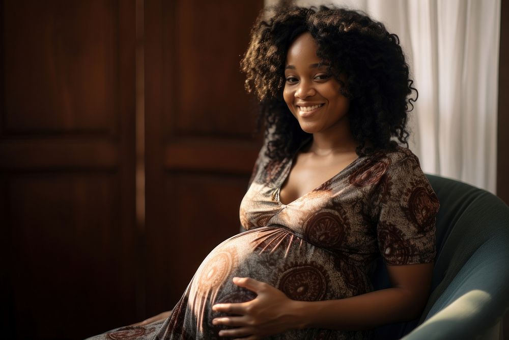 Black pregnant woman portrait smiling sitting. 