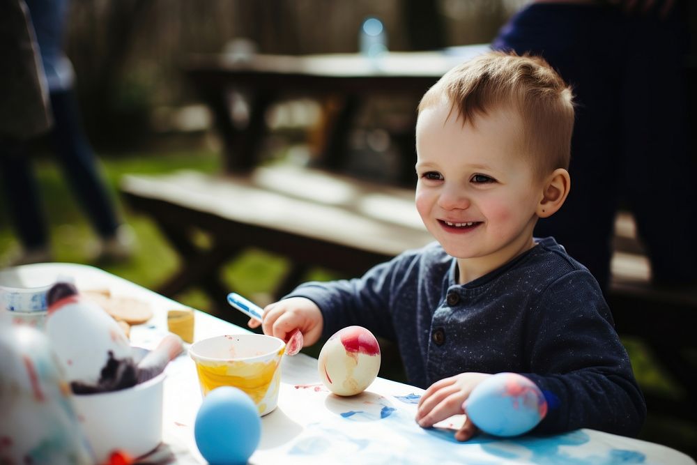 Kid painting easter eggs portrait smiling sitting. AI generated Image by rawpixel.
