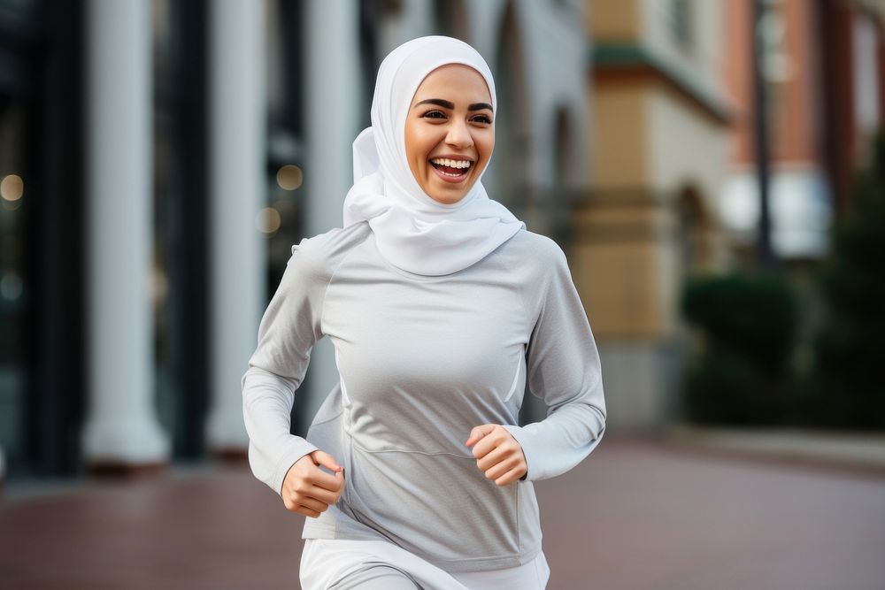 Muslim woman running smiling jogging. 