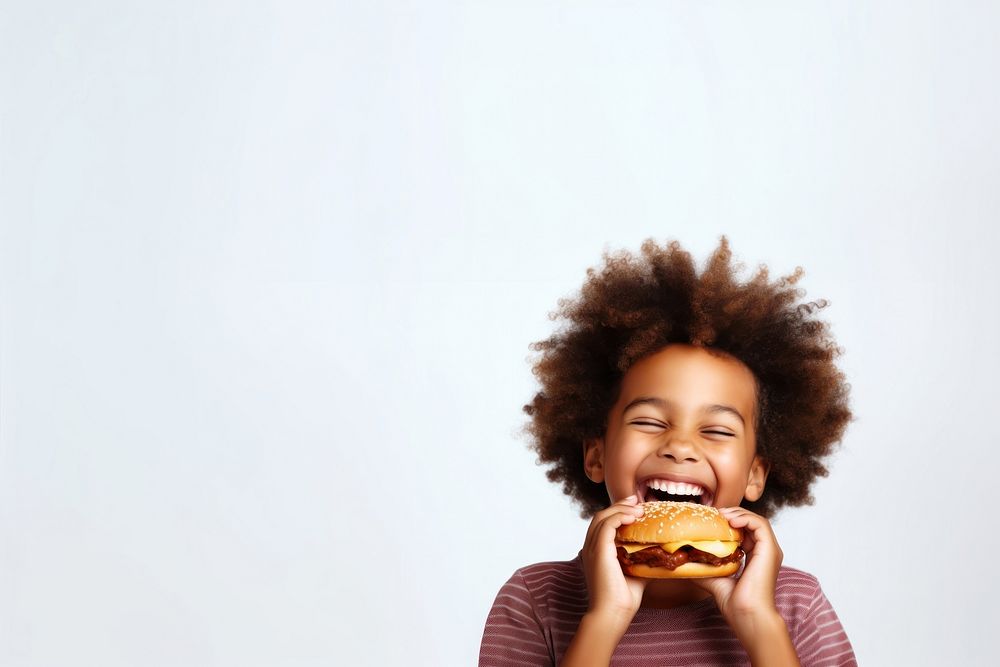 Cute little african boy enjoy eating a hamburger have fun biting child cute. AI generated Image by rawpixel.