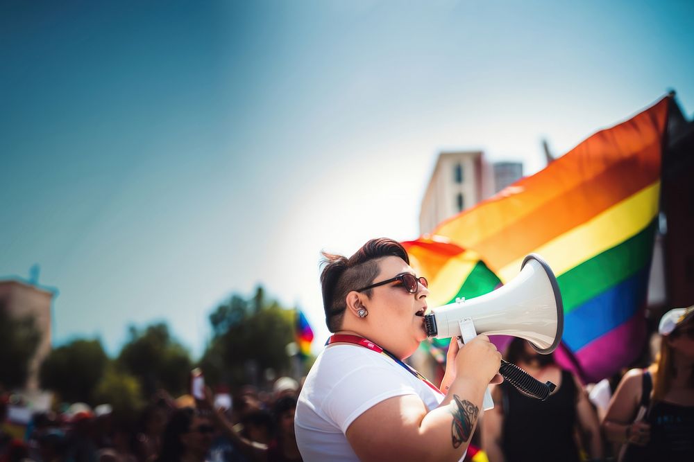 photo of plus size mexican lesbian woman using a megaphone at a pride parade.  